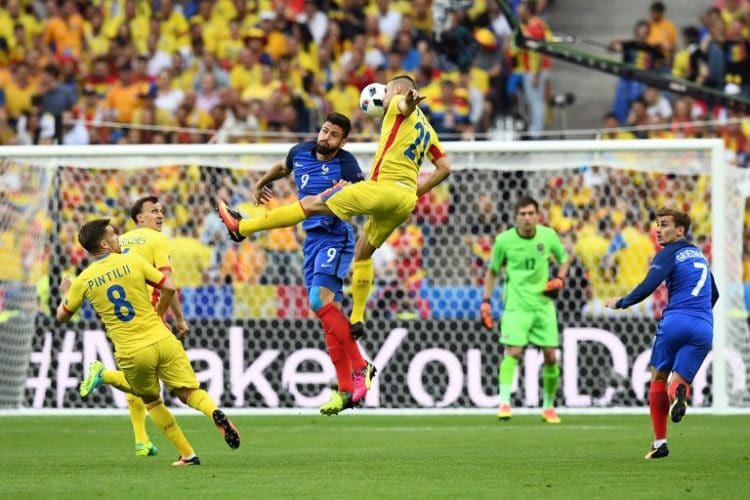 Olivier Giroud und Rumäniens Dragos Grigori (im Luftkampf. / AFP PHOTO / FRANCK FI