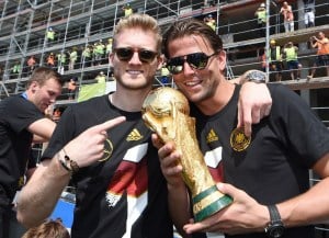 Andre Schuerrle und Roman Weidenfeller posieren mit dem Weltpokal nach dem Gewinn der Weltmeisterschaft bei der Rückkehr in Berlin.