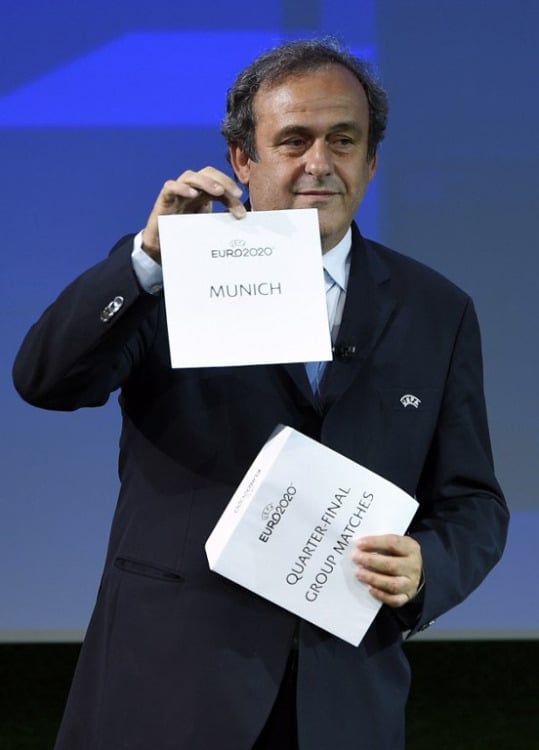 UEFA President Michel Platini hält die Karte für München hoch, in der drei Gruppenspiele und ein Viertelfinale stattfinden werden. ( AFP PHOTO / FABRICE COFFRINI )