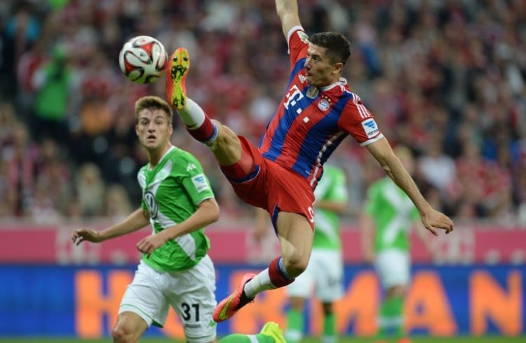 Bayern Munich's Polish striker Robert Lewandowski (R) and Wolfsburg's defender Robin Knoche (L) vie for the ball during the German first division Bundesliga football match FC Bayern Munich vs VfL Wolfsburg at the Allianz Arena in Munich, southern Germany on August 22, 2014. AFP PHOTO / CHRISTOF STACHE DFL RULES TO LIMIT THE ONLINE USAGE DURING MATCH TIME TO 15 PICTURES PER MATCH. IMAGE SEQUENCES TO SIMULATE VIDEO IS NOT ALLOWED AT ANY TIME. FOR FURTHER QUERIES PLEASE CONTACT DFL DIRECTLY AT + 49 69 650050.