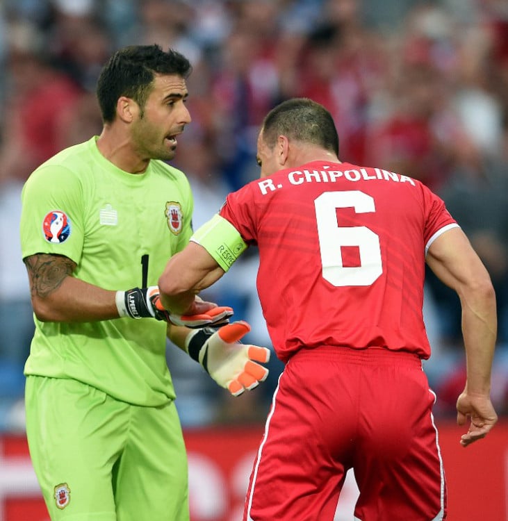 Gibraltar's Abwehrspieler Roy Chipolina gratuliert Torwart Jordan Perez (L) zum gehaltenen Elfmeter gegen Bastian Schweinsteiger beim Vorrundenspiel gegen Deutshcland in Faro am 13.Juni 2015. AFP PHOTO/ FRANCISCO LEONG