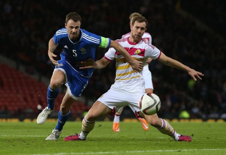 Nordirlands Jonny Evans (L) kämpft mit dem Schotten Steven Whittaker (R) am 25.März 2015. AFP PHOTO / IAN MACNICOL