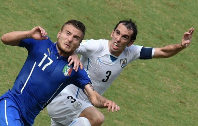 Italiens Stürmer Ciro Immobile (L) kämpft mit Uruguays Verteidiger Diego Godin während des Fußballspiels der Gruppe D zwischen Italien und Uruguay in der Dunas Arena in Natal während der FIFA Fussball-Weltmeisterschaft 2014 am 24. Juni 2014. AFP PHOTO/ YASUYOSHI CHIBA
