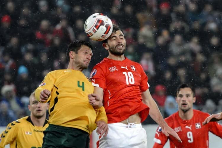 Litauens Abwehrspieler Tadas Kijanskas (L) und der Schweizer Angreifer Admir Mehmedi kämpfen um den Ball am 15. November 2014 in St Gallen. AFP PHOTO / FABRICE COFFRINI