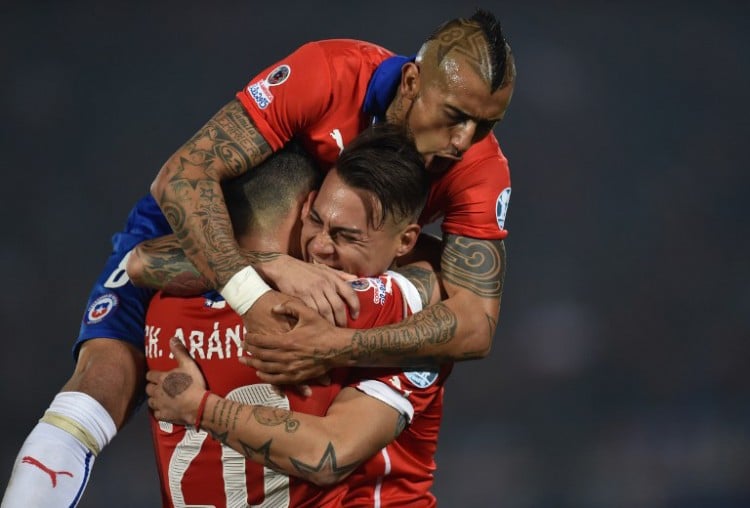 Chile's Stürmer Eduardo Vargas (C) feiert mit seinen Teamkollegen Charles Aranguiz und Arturo Vidal (top) den Gewinn der Copa America 2015 - und ist nun Platz 5 der FIFA-Weltrangliste. AFP PHOTO / RODRIGO ARANGUA