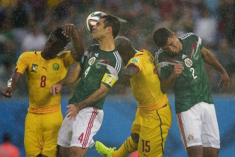 Kameruns Stürmer Benjamin Moukandjo und Kameruns Pierre Achille Webo (3L) kämpfen um den Ball mit Mexico's Kapitän Rafael Marquez und Mexico's Abwehrspieler Francisco Rodriguez (R) beim Spiel Mexico gegen Kamerun bei der WM 2014 (AFP PHOTO / PIERRE-PHILIPPE MARCOU)