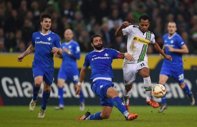 Moenchengladbachs Mittelfeldspieler Raffael und Darmstadts Abwehrspieler Aytac Sulu während des Spiels Borussia Moenchengladbach gegen SV Darmstadt in Moenchengladbach, Germany am Dezember 20, 2015. / AFP / PATRIK STOLLARZ /