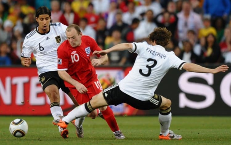 Deutschland gegen England bei der WM 2014: Arne Friedrich (R) und Sami Khedira (R) im Kampf mit Englands Wayne Rooney (Mitte). AFP PHOTO / PAUL ELLIS / AFP / PAUL ELLIS