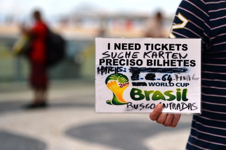 Auf der Suche nach Fußballtickets: Ein Mann am Copacabana beach in Rio de Janeiro hält ein Schild hoch und sucht Fußballtickets für das WM 2014 Finale. AFP PHOTO / GABRIEL BOUYS / AFP / GABRIEL BOUYS