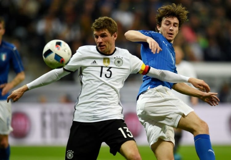 Thomas Müller und Italiens Matteo Darmian am 29.März 2016. / AFP / PATRIK STOLLARZ