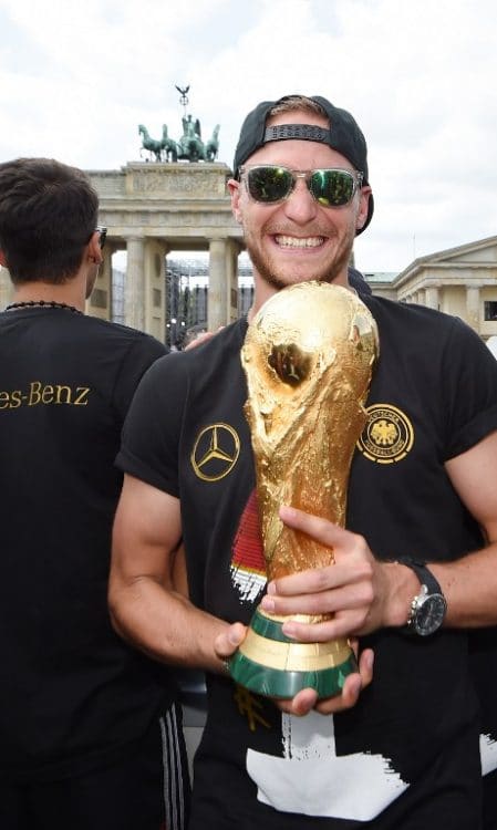 Höwedes mit WM-Pokal e. AFP PHOTO / POOL/ MARKUS GILLIAR / AFP / POOL / MARKUS GILLIAR