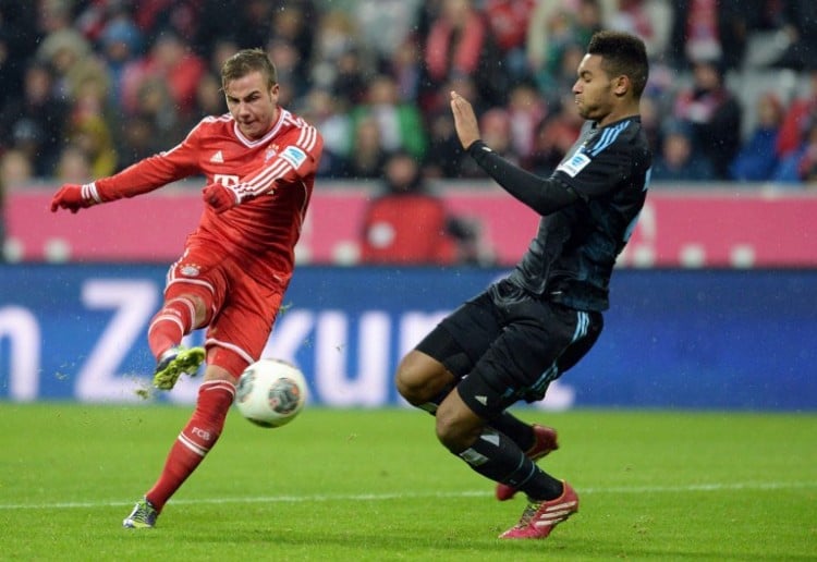 Bayern Münchens Mario Götze gegen HSV-Spieler Jonathan Tah am 14.Dezember 2013. AFP PHOTO/CHRISTOF STACHE