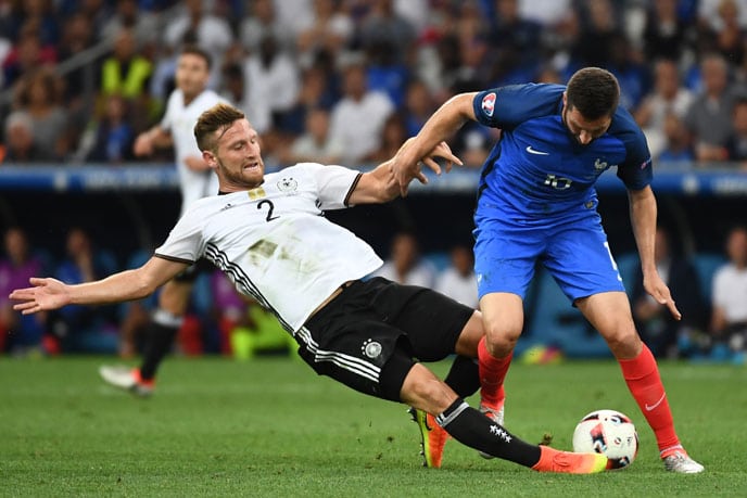 Shkodran Mustafi (L) im Zweikampf mit Andre-Pierre Gignac beim EM 2016 Halbfinale. / AFP PHOTO / ANNE-CHRISTINE POUJOULAT