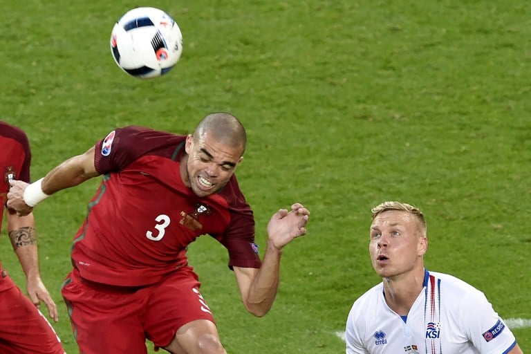 Portugal's defender Pepe (L) heads the ball tackled by Iceland's forward Kolbeinn Sigthorsson during the Euro 2016 group F football match between Portugal and Iceland at the Geoffroy-Guichard stadium in Saint-Etienne on June 14, 2016. / AFP PHOTO / JEAN-PHILIPPE KSIAZEK