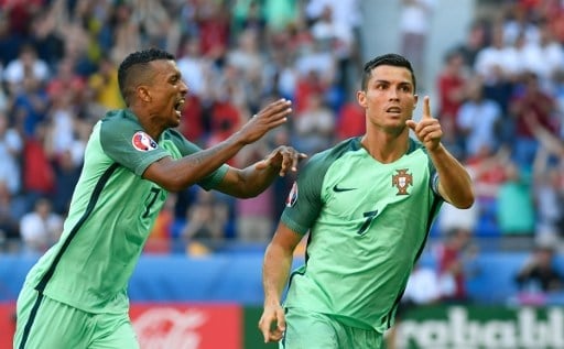 Portugal's forward Cristiano Ronaldo (R) celebrates after scoring a goal  during the Euro 2016 group F football match between Hungary and Portugal at the Parc Olympique Lyonnais stadium in Decines-Charpieu, near Lyon, on June 22, 2016. / AFP PHOTO / PHILIPPE DESMAZES