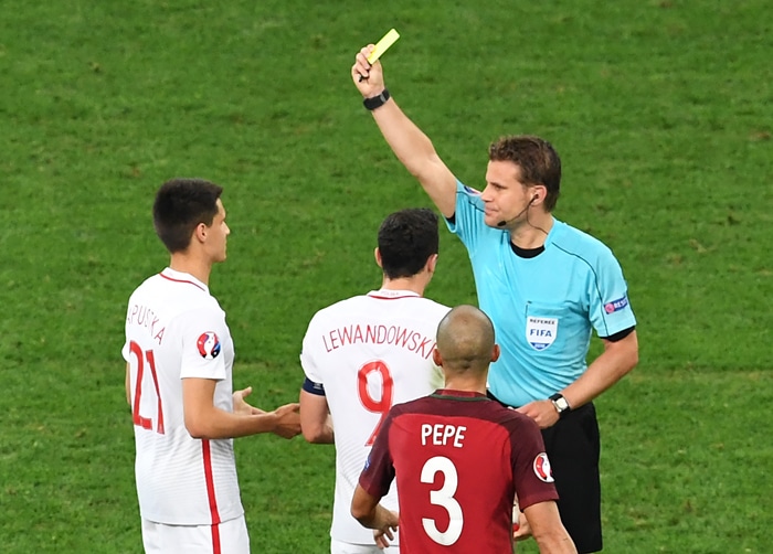 Der deutsche Schiedsrichter Felix Brych zeigt dem polnischen Mittelfeldspieler Bartosz Kapustka während des Viertelfinalspiels der Euro 2016 zwischen Polen und Portugal im Stade Velodrome in Marseille am 30. Juni 2016 die gelbe Karte. / AFP PHOTO / BORIS HORVAT