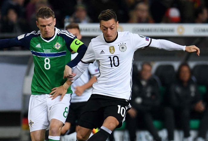 Mesut Özil (R) mit seiner neuen Rückennummer gegen Nordirlands Steven Davis beim WC 2018 Qualispiel in Hannover am 11.Oktober 2016. / AFP PHOTO / PATRIK STOLLARZ