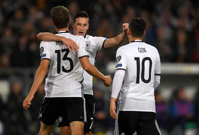 Julian Draxler (Mitte) feiert sein 1:0 gegen Nordirland. Thomas Müller (Nummer 13) und Mesut Özil (nun mit Rückennummer 10 statt 8 unterwegs) gratulieren ihm. / AFP PHOTO / PATRIK STOLLARZ