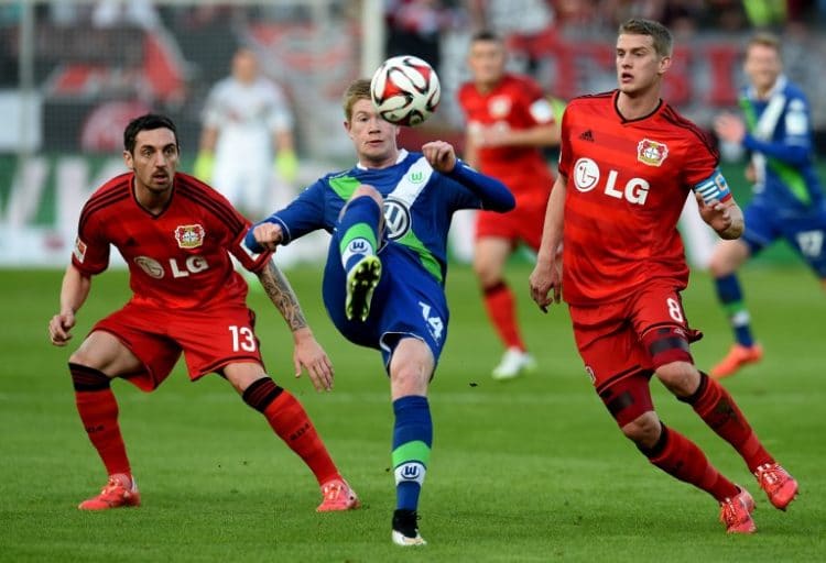 Wolfsburg's Kevin De Bruyne gegen Leverkusen's Lars Bender und Roberto Hilbert 2015. AFP PHOTO / PATRIK STOLLARZ
