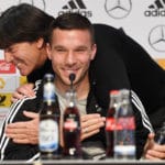 Gut gelaunt. Podolski und Löw auf der PK. PATRIK STOLLARZ / AFP