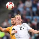 Julian Brandt beim Kopfballduell gegen Australien (3:2). Seine bisher starken Leistungen könnten der Schlüssel zum Erfolg für den DFB im schweren Spiel gegen Chile werden. Photo: AFP.