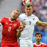 Russlands Denis Glushakov im Kopfballduell gegen Neuseeland. Anders als im Bild konnte Russland am Ende mit 2:0 die Oberhand behalten. Heute geht es jedoch gegen einen schwereren Gegner, den amtierenden Europameister aus Portugal. Photo: AFP.
