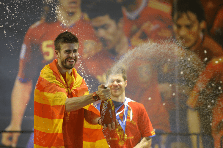 Spaniens Gerard Pique (hier nach dem Gewinn der Fußball WM 2010) wird am heutigen Spieltag im Blickpunkt stehen - er kommt aus Katalonien und zeigt dies auch: mit der katalonischen Fahne! AFP PHOTO / MIGUEL RIOPA / 