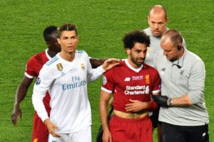 Liverpools Ägyptischer Stürmerstar Mohamed Salah (Mitte) wird von Seinen Mitspielern und Cristiano Ronaldo getröstet als er im Champions League Finale zwischen Liverpool und Real Madrid den Platz verletzt verlassen muss. Aktuell scheint die WM Teilnahme für Salah allerdings nicht gefähredet. Es scheint sich nur um eine Bänderdehnung und Prellung der Schulter zu handeln. 26. Mai 2018, Olympiastadion Kiew. / AFP PHOTO / Sergei SUPINSKY
