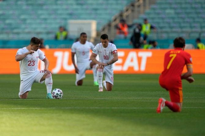 (v.l.n.r.) Der Schweizer Mittelfeldspieler Xherdan Shaqiri, der Schweizer Verteidiger Manuel Akanji, der Schweizer Mittelfeldspieler Granit Xhaka und der walisische Mittelfeldspieler Joe Allen knien sich während des Fußballspiels der UEFA EURO 2020 Gruppe A zwischen Wales und der Schweiz im Olympiastadion in Baku am 12. Juni 2021 nieder. Darko Vojinovic / POOL / AFP