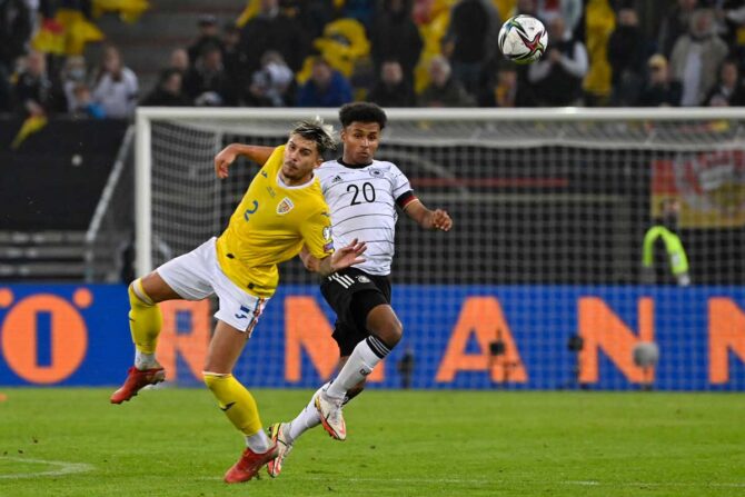 Rumäniens Verteidiger Andrei Ratiu (L) und Deutschlands Mittelfeldspieler Karim Adeyemi kämpfen um den Ball während des Fußballspiels Deutschland gegen Rumänien in der Gruppe J der FIFA Fussball-Weltmeisterschaft Katar 2022 am 8. Oktober 2021 in Hamburg, Norddeutschland. - Deutschland hat das Spiel mit 2:1 gewonnen. (Foto: John MACDOUGALL / AFP)