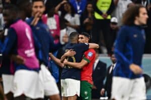 Frankreichs Stürmer Nr. 10, Kylian Mbappe, und Marokkos Verteidiger Nr. 02, Achraf Hakimi nach dem Halbfinalspiel der Fußball-Weltmeisterschaft 2022 in Katar zwischen Frankreich und Marokko im Al-Bayt-Stadion in Al Khor, nördlich von Doha, am 14. Dezember 2022. - Frankreich hat 2:0 gewonnen. (Foto: GABRIEL BOUYS / AFP)