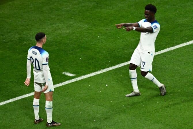 Englands Stürmer Nr. 17 Bukayo Saka (R) feiert den dritten Treffer seiner Mannschaft mit Englands Stürmer Nr. 20 Phil Foden (L) während des Achtelfinales der Fußballweltmeisterschaft Katar 2022 zwischen England und Senegal im Al-Bayt-Stadion in Al Khor, nördlich von Doha, am 4. Dezember 2022. (Foto: Jewel SAMAD / AFP)