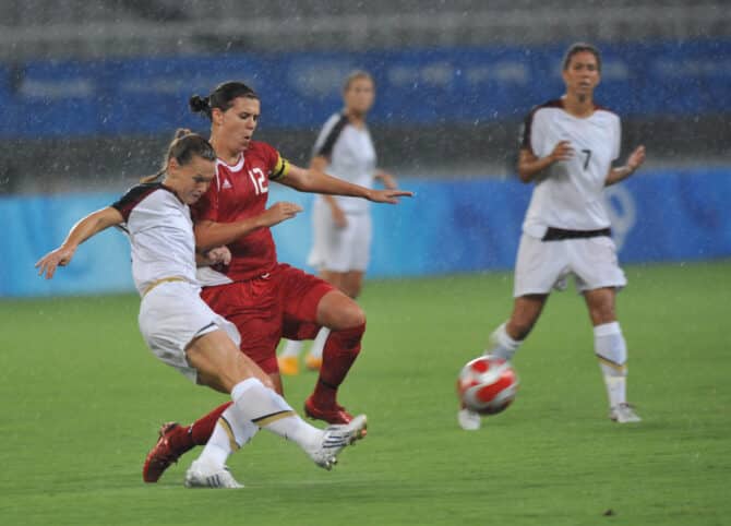 Christine SINCLAIR aus Kanada (R) kämpft mit einer Spielerin der USA während eines Viertelfinalspiels der Olympischen Spiele 2008 in Peking im Shanghai-Stadion in Shanghai, 15. August 2008.Die USA besiegten Kanada mit 2:1. (Copyright depositphotos.com)