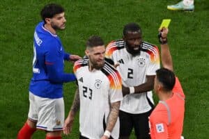 Der spanische Schiedsrichter Jesus Gil Manzano (R) zeigt dem deutschen Mittelfeldspieler Robert Andrich (2L) die gelbe Karte während des Freundschaftsspiels zwischen Frankreich und Deutschland im Groupama-Stadion in Decines-Charpieu, in der Nähe von Lyon, am 23. März 2024. (Foto von JEAN-PHILIPPE KSIAZEK / AFP)FIFE / AFP)