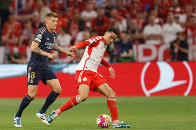 Bayern Münchens (#42) Jamal Musiala (R) und Real Madrids (#08) Toni Kroos kämpfen um den Ball während des Halbfinal-Hinspiels der UEFA Champions League zwischen dem FC Bayern München und Real Madrid CF am 30. April 2024 in München, Süddeutschland. (Foto: Michaela STACHE / AFP)