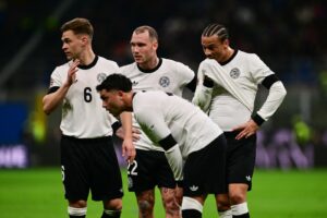 (v.l.) Der deutsche Mittelfeldspieler Joshua Kimmich (Nr. 06), der deutsche Verteidiger David Raum (Nr. 22) und der deutsche Verteidiger Maximilian Mittelstaedt (Nr. 18) schauen während des Viertelfinal-Hinspiels der Nations League zwischen Italien und Deutschland im San-Siro-Stadion in Mailand am 20. März 2025 zu. (Foto: Marco BERTORELLO / AFP)