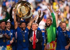 EAST RUTHERFORD, NEW JERSEY - 13. JULI: Reece James (24) vom FC Chelsea hebt nach dem Sieg seiner Mannschaft die Trophäe der FIFA Klub-Weltmeisterschaft 2025 in die Höhe, während US-Präsident Donald Trump nach dem Endspiel der FIFA Klub-Weltmeisterschaft 2025 zwischen dem FC Chelsea und Paris Saint-Germain im MetLife Stadium am 13. Juli 2025 in East Rutherford, New Jersey, eine Reaktion zeigt. David Ramos/Getty Images/AFP (Foto: David Ramos / GETTY IMAGES NORTH AMERICA / Getty Images via AFP)
