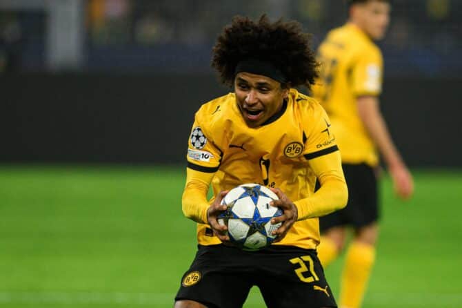 DORTMUND, 25. NOVEMBER 2025: Karim Adeyemi, Flügelspieler von Borussia Dortmund, hält den Champions-League-Spielball und reißt den Mund auf — sichtlich emotional beim UEFA-Champions-League-Gruppenspiel gegen den FC Villarreal im Signal Iduna Park. Der BVB-Stürmer trägt das gelb-schwarze Heimtrikot mit der Nummer 27. (Copyright Depositphotos.com)