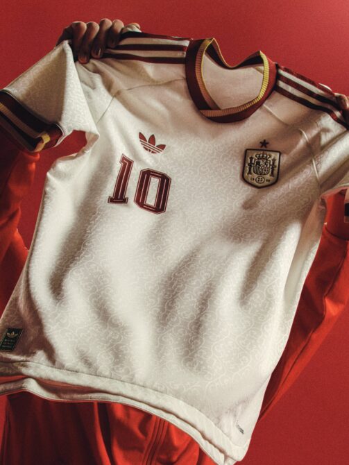 Das neue adidas Originals Auswärtstrikot von Spanien für die WM 2026 – weißes Trikot mit weinroten und goldenen Kragen- und Ärmeldetails sowie dem RFEF-Wappen.