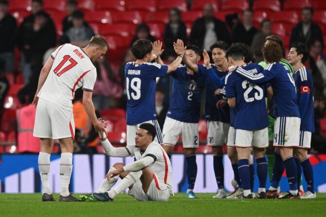 Dan Burn und Morgan Rogers von England sind nach der Niederlage gegen Japan enttäuscht, während die japanischen Spieler ihren Sieg im Wembley Stadium am 31. März 2026 in London feiern. Mike Hewitt / Getty Images