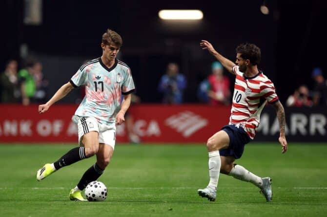 Charles De Ketelaere (Belgien) passt den Ball unter Druck von Christian Pulisic (USA) im Länderspiel im Mercedes-Benz Stadium in Atlanta am 28. März 2026. Jared C. Tilton / Getty Images