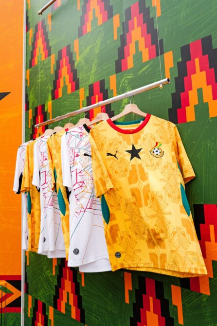 Die neuen Puma-Trikots der ghanaischen Nationalmannschaft beim WM-2026-Launch in New York am 19. März 2026: Das goldgelbe Heimtrikot mit dem Black Star sowie das weiße Auswärtstrikot vor einem farbenfrohen Kente-inspirierten Hintergrund. (Copyright Puma)
