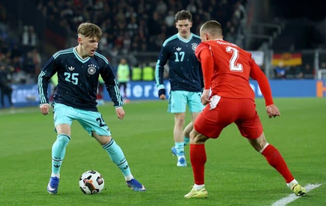 Lennart Karl (#25) behauptet sich im Zweikampf mit Miro Muheim von der Schweiz beim Länderspiel im St. Jakob-Park in Basel am 27. März 2026. Im Hintergrund Florian Wirtz (#17). Alexander Hassenstein / Getty Images