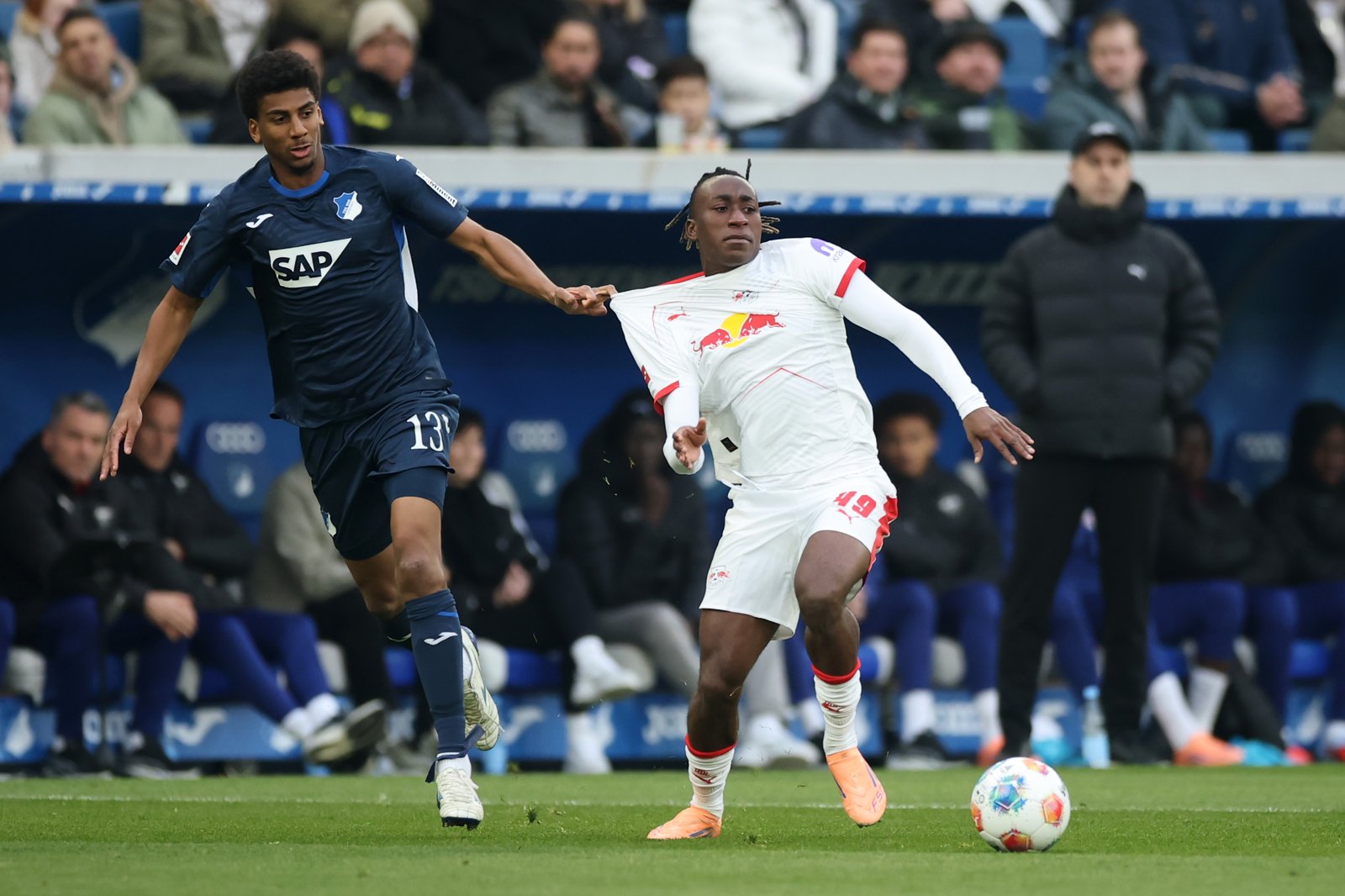 Yan Diomande von RB Leipzig wird von Bernardo der TSG 1899 Hoffenheim im Bundesliga-Spiel in der PreZero Arena in Sinsheim am 8. November 2025 unter Druck gesetzt. Foto: Alex Grimm / Getty Images