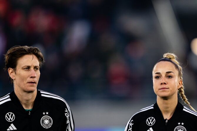 Ann-Katrin Berger und Giulia Gwinn von der deutschen Frauennationalmannschaft stehen nebeneinander während der Nationalhymnen vor dem WM-Qualifikationsspiel für die Frauen-WM 2027 gegen Norwegen in der Lyse Arena in Stavanger am 7. März 2026. Foto: Marius Nordnes / Nordnes Foto / Getty Images Europe via Getty Images