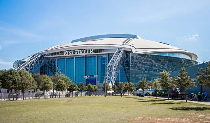 Das AT&T Stadium in Arlington bei Dallas aus der Außenperspektive – die imposante Heimstätte der Dallas Cowboys mit ihrer markanten Glashülle und dem Bogendach ist einer der Austragungsorte der FIFA Fußball-Weltmeisterschaft 2026 in den USA. (Copyright Depositphotos.com)