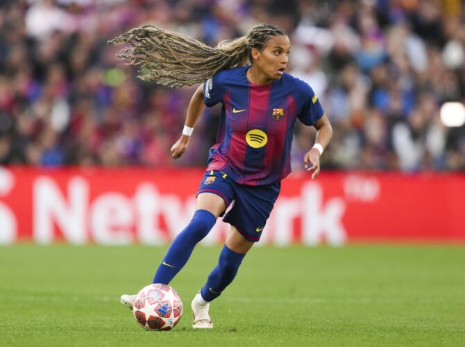 Eine Barcelona Spielerin dribbelt mit dem Fußball im Frauen Champions League Viertelfinale gegen Real Madrid. Mit fliegenden Dreadlocks läuft sie über das Spielfeld im beliebten Barcelona Frauen-Trikot. Getty Images