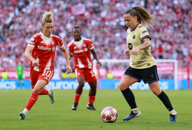 Bayern München Spielerin im roten Allianz-Trikot im Duell mit Barcelona-Spielerin im Champions League Halbfinale Frauen. Das intensive Fußballspiel in der Allianz Arena mit voller Tribüne. Getty Images