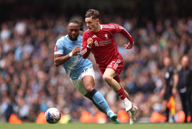 Florian Wirtz vom FC Liverpool treibt am 4. April 2026 im Etihad Stadium in Manchester den Ball nach vorne, während Antoine Semenyo von Manchester City Druck macht. Die Szene ereignete sich im Viertelfinale des Emirates FA Cup. Foto: Carl Recine / Getty Images Europe