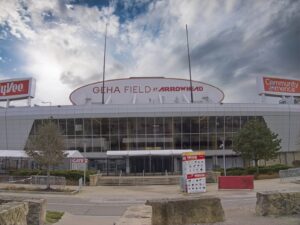 Außenansicht des GEHA Field at Arrowhead Stadium in Kansas City, Missouri, aufgenommen am 28. Dezember 2023. Das Stadion, Heimspielstätte der Kansas City Chiefs aus der NFL, ist Austragungsort der FIFA Fußball-Weltmeisterschaft 2026. Der Eingangsbereich mit dem markanten Stadionschriftzug ist vor einem dramatischen Wolkenhimmel zu sehen. (Copyright Depositphotos.com)